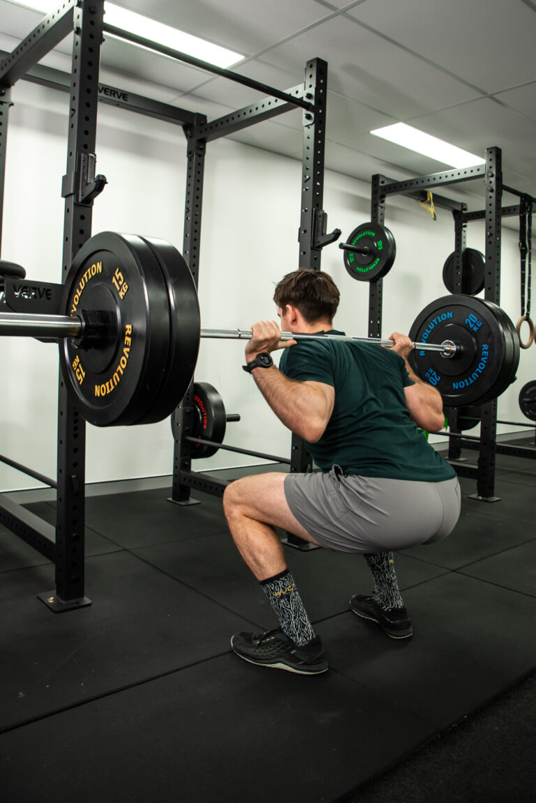 Image of Matt from Keen Physique squatting in his personal training studio in Milton, Brisbane.