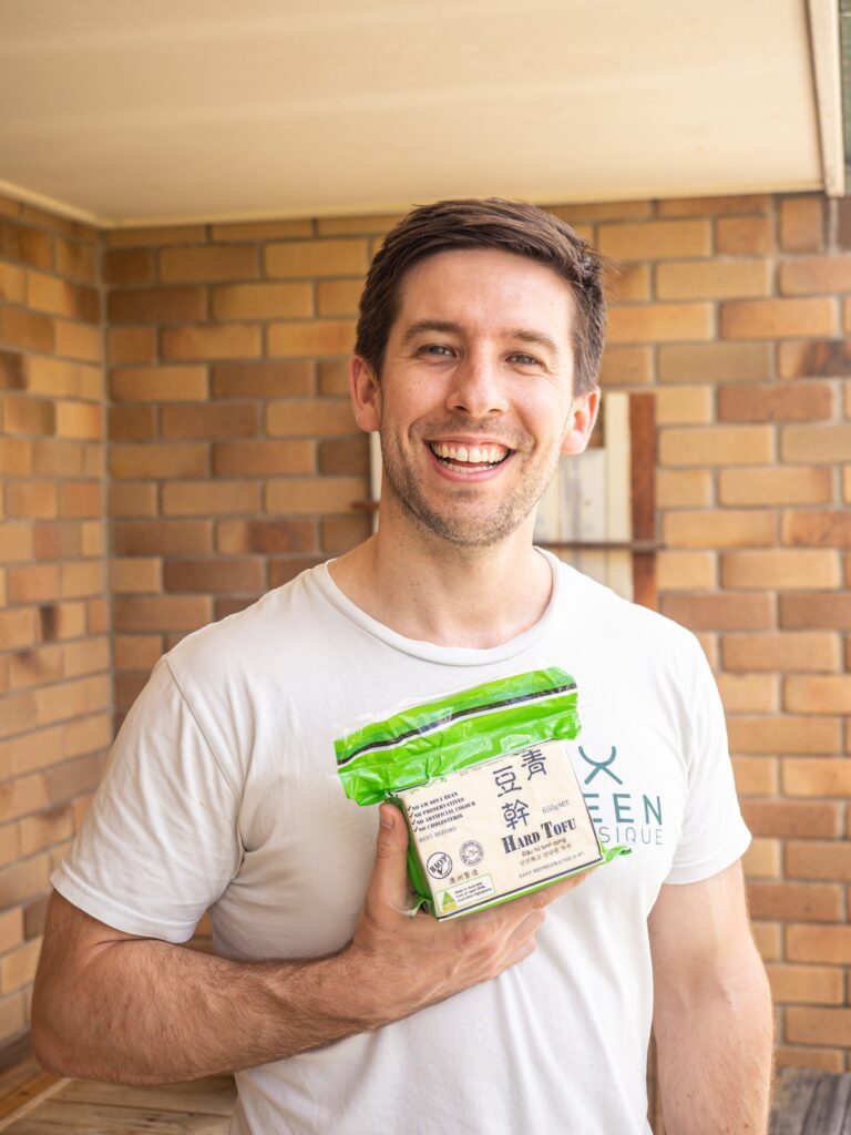 Photo of Keen Physique owner & trainer Matt holding Evergreen Hard Tofu